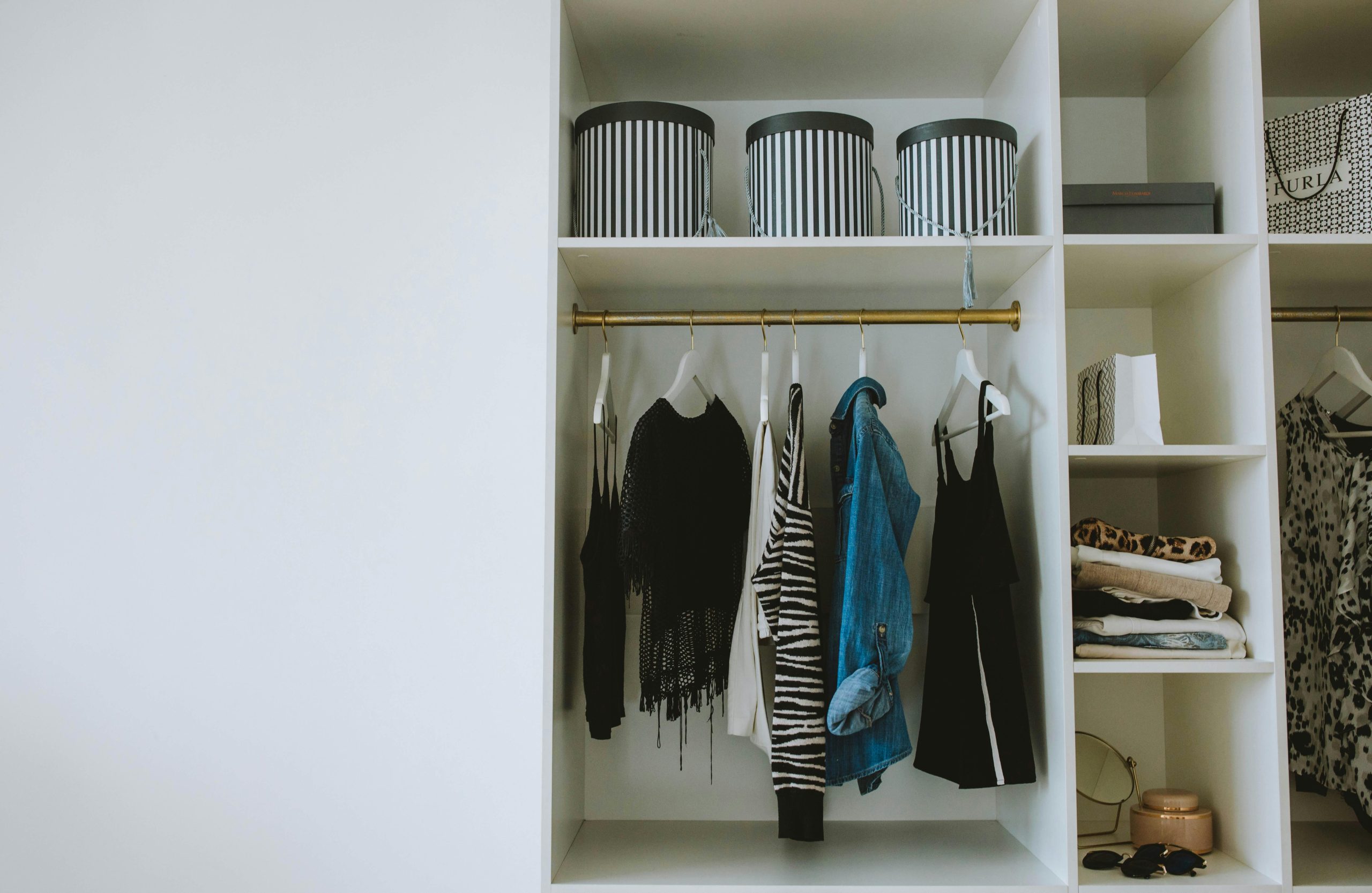 white closet with clothes and chic storage boxes